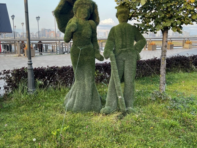 Скульптура из травы Джентельмен и дама с зонтиком на Кремлевской набережной